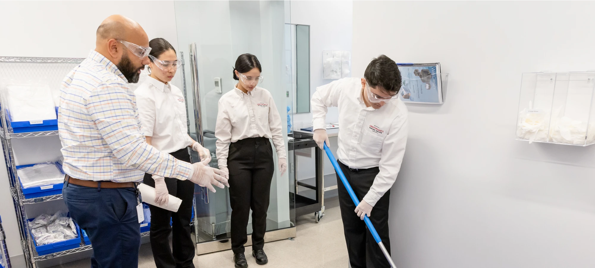 Cleaning staff in safety goggles receiving hands-on training for sanitation procedures