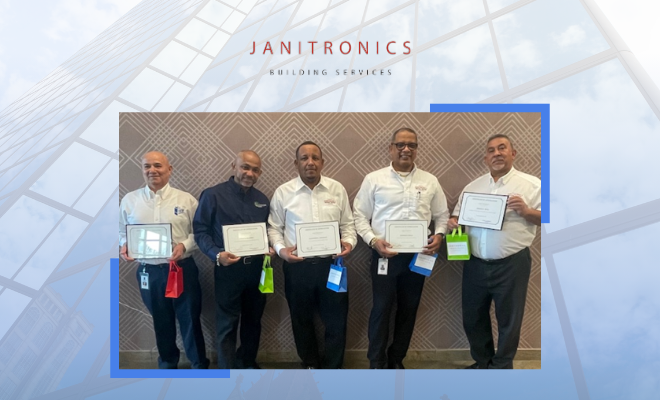 Janitronics employees proudly display certificates and gifts at a company recognition event