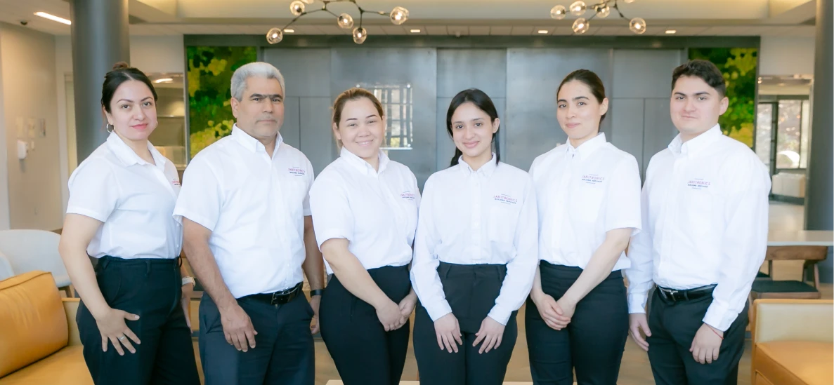 Janitronics team posing in uniform inside a stylish office lobby with modern decor