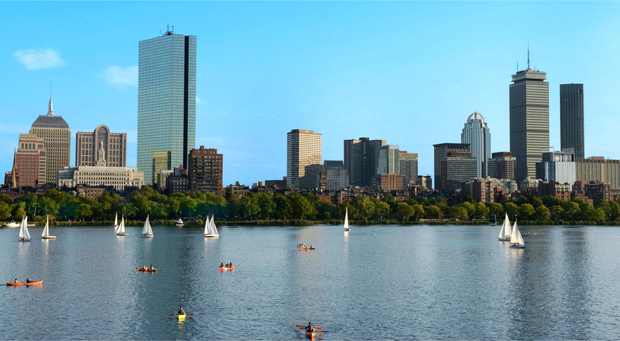 Boston skyline view from the Charles River with sailboats and kayaks on the water