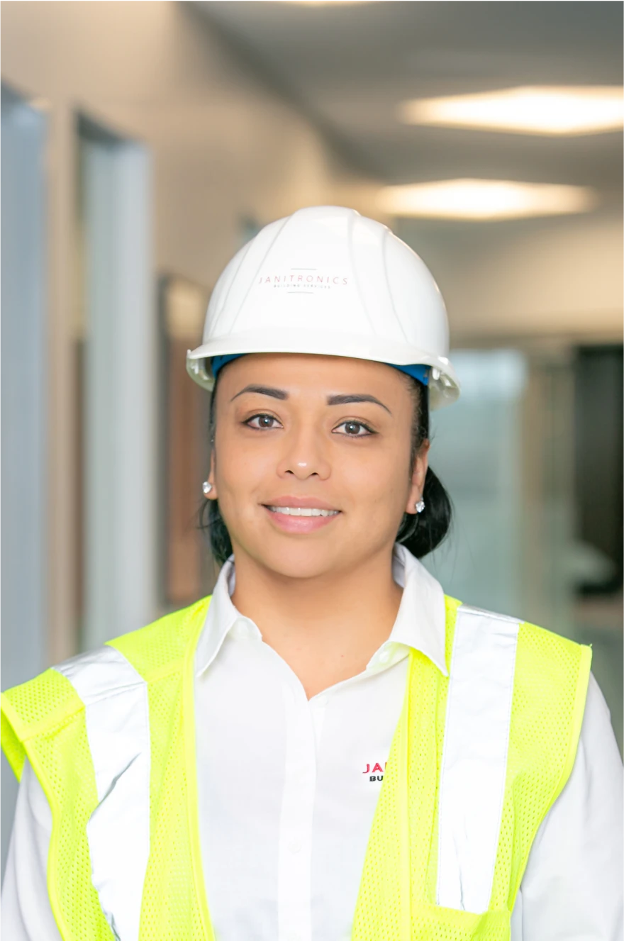 Janitronics employee posing confidently in safety gear at a worksite