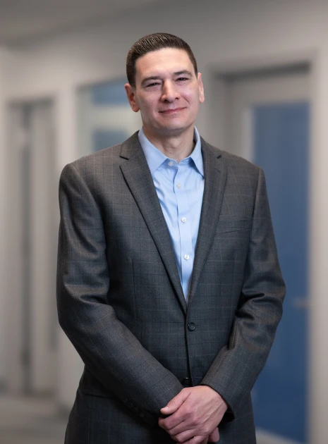 Portrait of executive man in tailored suit standing confidently in company building hallway