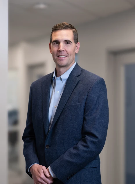 Corporate leader wearing crisp blue blazer and shirt during photo session in office corridor